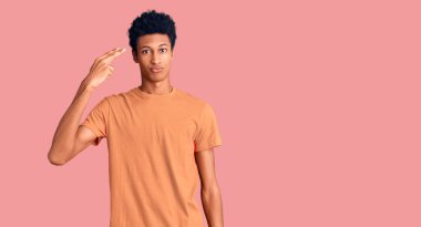 Genç, Afro-Amerikan bir adam, günlük giysiler giymiş, silah gibi elini ve parmaklarını havaya kaldırarak ateş ediyor ve öldürüyor.. 