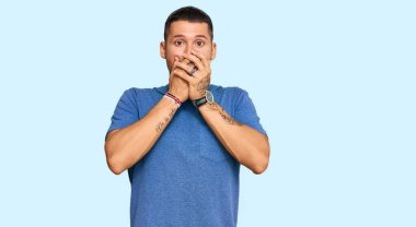 Sıradan kıyafetler giyen yakışıklı bir adam ağzını yanlışlıkla elleriyle kapatırken şok geçirdi. gizli kavram. 