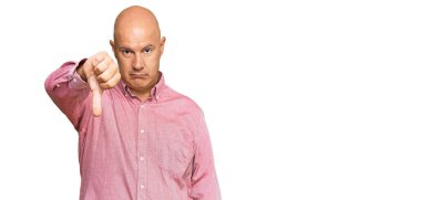 Orta yaşlı, kel, sıradan kıyafetler giyen mutsuz, kızgın, reddedilmiş ve olumsuz hareketler yapan bir adam. kötü ifade. 