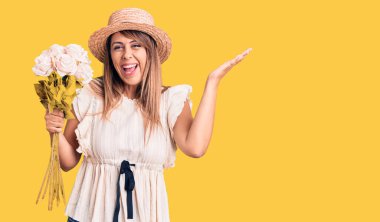 Şapka takan güzel bir kadın elinde bir buket çiçekle zaferi mutlu bir gülümsemeyle kutluyor ve kazanan el kaldırarak ifade ediyor. 