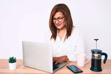 Orta yaşlı esmer, ispanyol iş kadını ofiste çalışıyor. Olumlu ve mutlu görünüyor. Kendine güvenen bir gülümsemeyle dişlerini gösteriyor. 