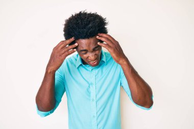 Yakışıklı, afro saçlı, başı ağrıyan, günlük kıyafetler giyen Afro-Amerikan bir adam. migren ağrısı. 