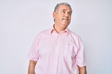 Kıdemli, gri saçlı, günlük kıyafetler giyen, rahat bir görünüm takınan, doğal yüzlü ve kendine güvenen bir gülümseme takınan adam.. 