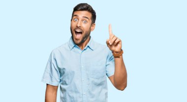 Sıradan kıyafetler giyen yakışıklı İspanyol adam başarılı bir fikirle işaret ediyor. Heyecanlı ve mutlu. Bir numara.. 