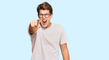 Sıradan kıyafetler ve gözlük takan yakışıklı beyaz adam kameraya kızgın ve sinirli olduğunu gösteriyor. 