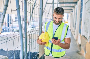 Genç İspanyol mimar şehrin caddesinde akıllı telefon kullanarak projeyi tutuyor.