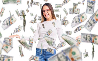 Güzel esmer, beyaz süveter ve gözlük takan genç bir kadın gülümseyerek avuçlarını açıyor, sunuyor ve reklam karşılaştırması yapıyor ve dengeyi sağlıyor.