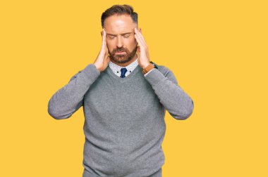 Yakışıklı, orta yaşlı, iş elbiseleri giyen, eli başının üstünde, stres yüzünden başı ağrıyan bir adam. migren ağrısı. 