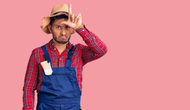 Yakışıklı Latin Amerikalı genç adam tamirci üniforması giyiyor. Alnında parmakları olan insanlarla dalga geçiyor. Ezik hareketler yapıyor, alay ediyor ve hakaret ediyor.. 