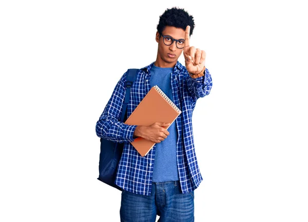 若いアフリカ系アメリカ人の男を着て学生のバックパックを保持本を指して指アップと怒りの表現 ジェスチャーを示しません — ストック写真
