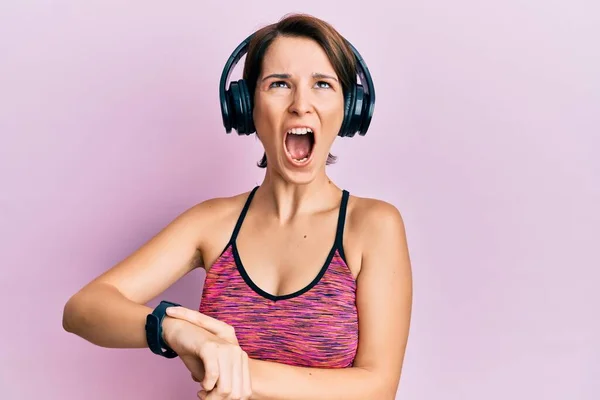 Young Brunette Woman Short Hair Using Headphones Smart Watch Angry — Stock Photo, Image