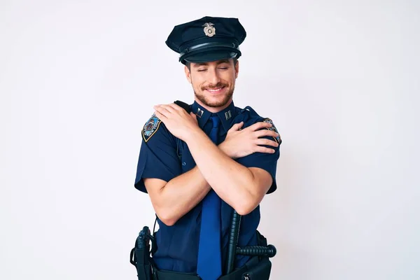 Ung Hvid Mand Iført Politiuniform Kramme Sig Selv Glad Positiv - Stock-foto