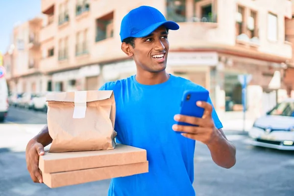 Africano Homem Entrega Vestindo Courier Uniforme Livre Usando Smartphone — Fotografia de Stock