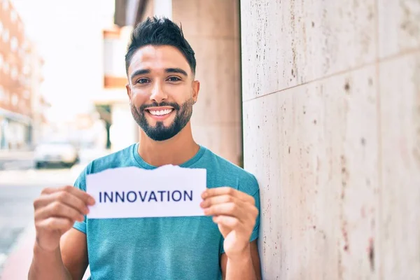 Jovem Árabe Homem Sorrindo Feliz Segurando Inovação Palavra Papel Encostado — Fotografia de Stock
