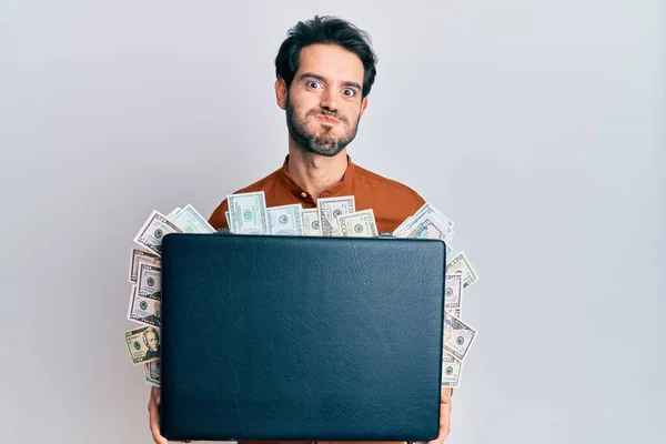 Young Hispanic Man Holding Briefcase Dollars Puffing Cheeks Funny Face — Stock Photo, Image