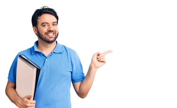 Jonge Spaanse Man Met Notebook Glimlachend Vrolijk Wijzend Met Hand — Stockfoto
