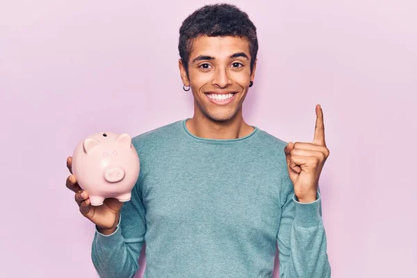 Jovem Afro Americano Segurando Porquinho Banco Sorrindo Com Uma Ideia — Fotografia de Stock