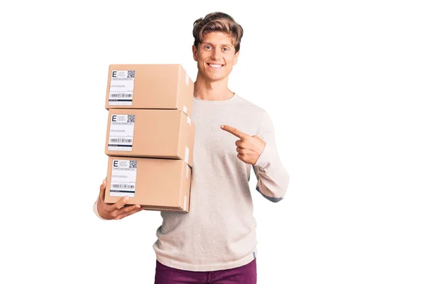Genç Yakışıklı Adam Teslimat Paketini Tutuyor Gülümsüyor Mutlu Parmaklarıyla Işaret — Stok fotoğraf