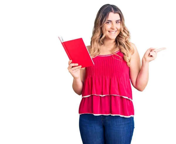 Joven Mujer Caucásica Sosteniendo Libro Sonriendo Feliz Señalando Con Mano —  Fotos de Stock