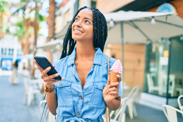 年轻的非洲裔美国女人在城市里用智能手机吃冰激凌 — 图库照片