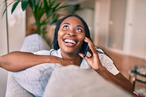 若いアフリカ系アメリカ人女性笑顔幸せな座って使用してスマートフォンにホーム — ストック写真