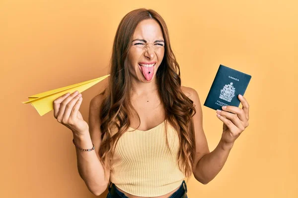 Joven Morena Sosteniendo Avión Papel Pasaporte Canadiense Sacando Lengua Feliz — Foto de Stock