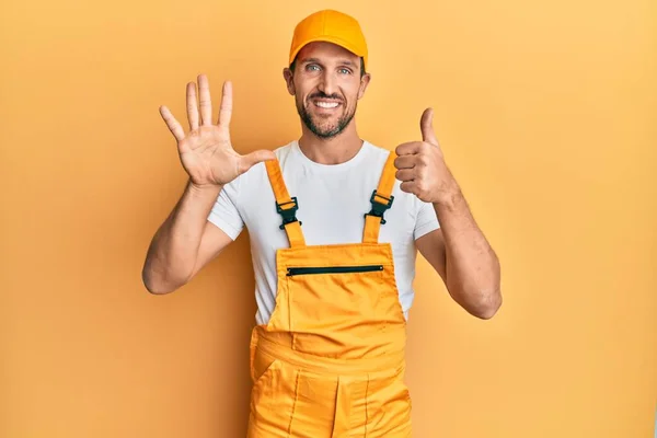 Ung Stilig Man Bär Handyman Uniform Över Gul Bakgrund Visar — Stockfoto