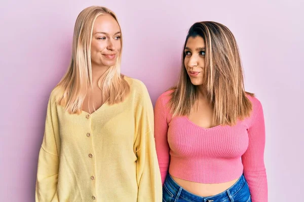 Zwei Freunde Stehen Zusammen Auf Rosa Hintergrund Lächelnd Zur Seite — Stockfoto