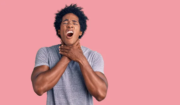 Handsome african american man with afro hair wearing casual clothes shouting and suffocate because painful strangle. health problem. asphyxiate and suicide concept.