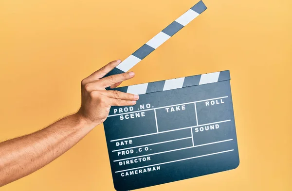 Dłoń Latynoskiego Człowieka Trzymając Film Clapboard Odizolowanym Żółtym Tle — Zdjęcie stockowe