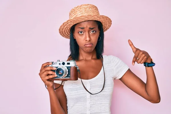 Mujer Afroamericana Joven Con Sombrero Verano Sosteniendo Cámara Vintage Apuntando —  Fotos de Stock