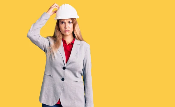 Mooie Jonge Vrouw Draagt Architect Hardhat Verwarren Verwonderen Vraag Onzeker — Stockfoto