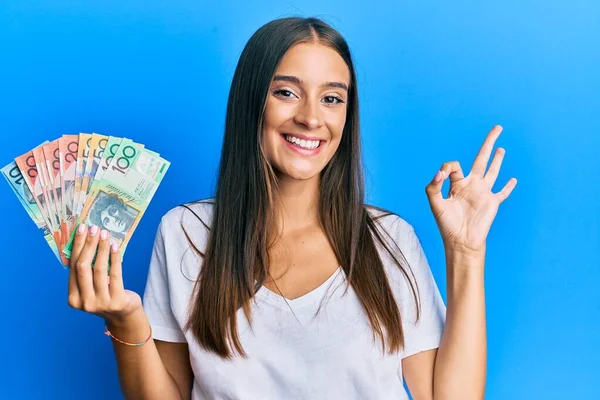 Młoda Latynoska Kobieta Trzyma Australijskie Dolary Robi Znak Palcami Uśmiechając — Zdjęcie stockowe