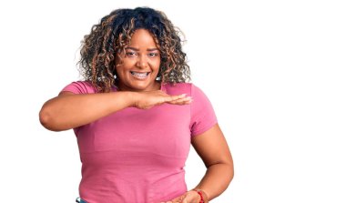 Genç Afro-Amerikan artı cüsseli kadın. Elleri büyük ve büyük boy işareti olan günlük kıyafetler giyiyor. Ölçüm sembolü. Kameraya bakıp gülümsüyor. ölçüm kavramı. 