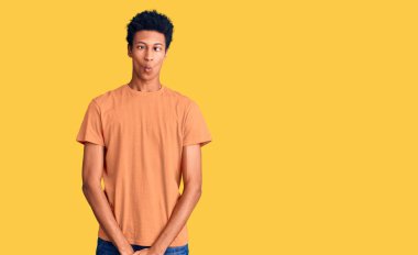 Genç Afro-Amerikan adam günlük kıyafetler giyip dudaklarıyla balık suratı yapıyor, çılgınca ve komik bir jest. Komik ifade. 