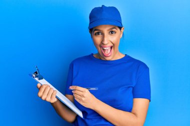 Kurye üniforması giyen güzel esmer kadın elinde pano tutarak çılgınlığı kutluyor ve başarı için hayrete düşüyor.. 