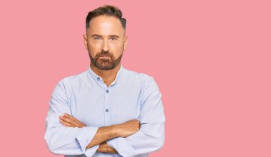 Yakışıklı, orta yaşlı, iş gömleği giyen şüpheci ve gergin, yüzünde çapraz kollu tasvip etmeyen bir ifade. negatif kişi. 