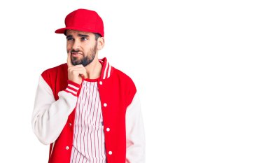 Sakallı, beysbol ceketli, şapkalı, ciddi yüzlü, eli çenesinde soru soran yakışıklı bir genç. Kafa karıştırıcı bir fikir. 