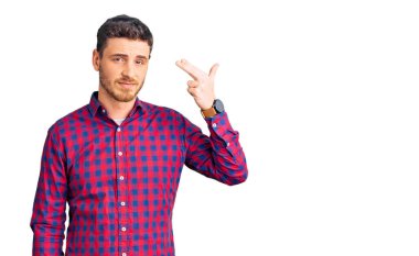 Ayılı yakışıklı genç adam, sıradan bir tişört giyiyor ve kendini vuruyor elini ve parmaklarını silah gibi kullanıyor, intihar jesti.. 