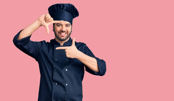 Mladý Hispánec Kuchařské Uniformě Usmívá Vytváří Rámeček Rukama Prsty Šťastnou — Stock fotografie