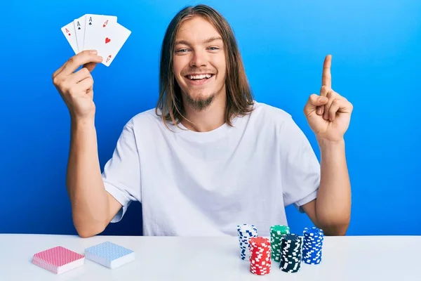 Knappe Blanke Man Met Lang Haar Spelen Poker Holding Cards — Stockfoto