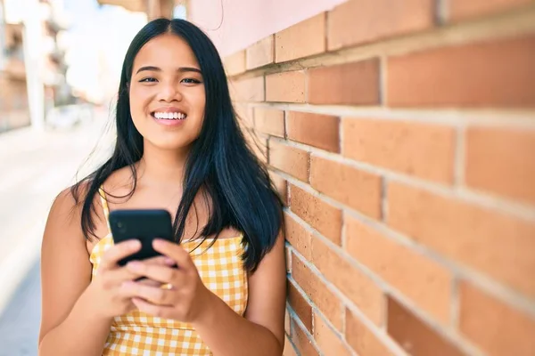 Νεαρή Ασιάτισσα Χαμογελά Ευτυχισμένη Στην Πόλη Χρησιμοποιώντας Smartphone — Φωτογραφία Αρχείου