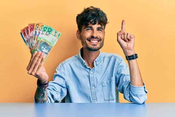 Jovem Hispânico Segurando Dólares Australianos Sentado Mesa Sorrindo Com Uma — Fotografia de Stock