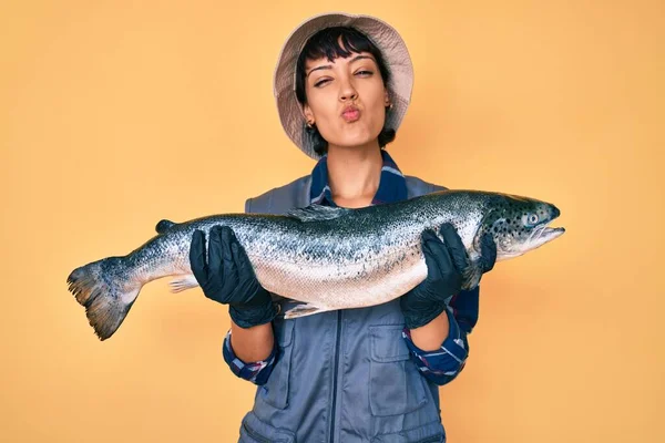 Hermosa Morena Pescador Mujer Mostrando Salmón Crudo Mirando Cámara Soplando —  Fotos de Stock