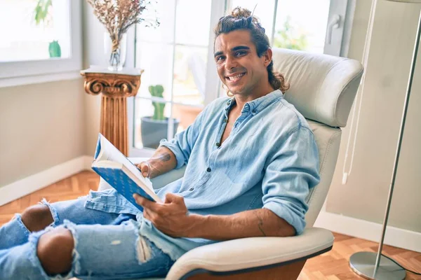 Joven Hispano Sonriendo Feliz Libro Lectura Casa — Foto de Stock