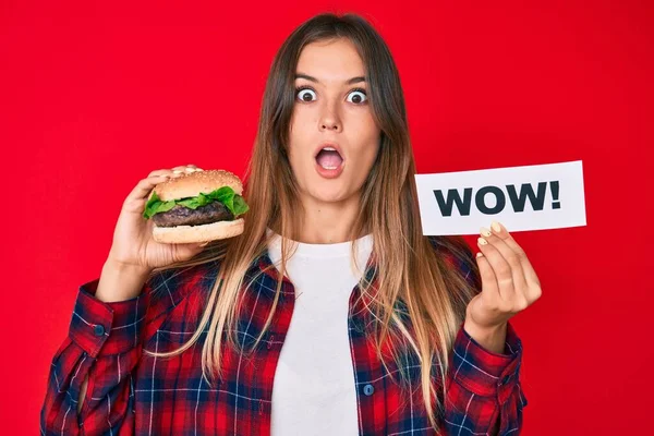 Hermosa Mujer Caucásica Comiendo Una Sabrosa Hamburguesa Clásica Sosteniendo Wow — Foto de Stock