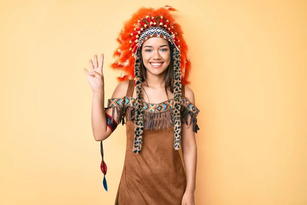 若いです美しいですラテン女の子身に着けていますインディアン衣装ショーとポイントアップとともに指番号4ながら笑顔自信と幸せ — ストック写真