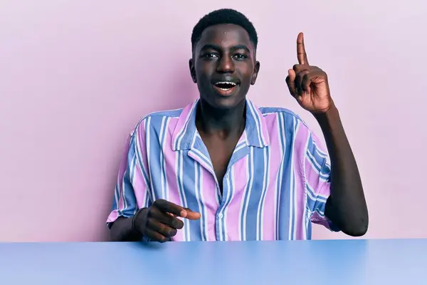 Ung Afrikansk Amerikan Vardagskläder Som Sitter Bordet Och Pekar Finger — Stockfoto