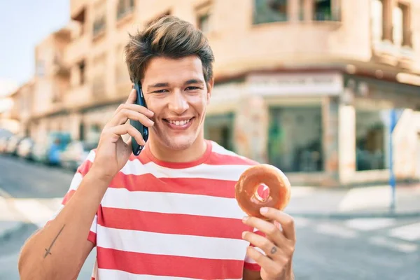Νεαρός Καυκάσιος Μιλάει Στο Smartphone Τρώγοντας Ντόνατ Στην Πόλη — Φωτογραφία Αρχείου
