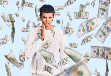 Sıradan kıyafetler giyen, diş ağrısı ya da diş hastalığından dolayı acı dolu bir ifadeyle dudaklarına dokunan Afrikalı genç bir Amerikalı. dişçi